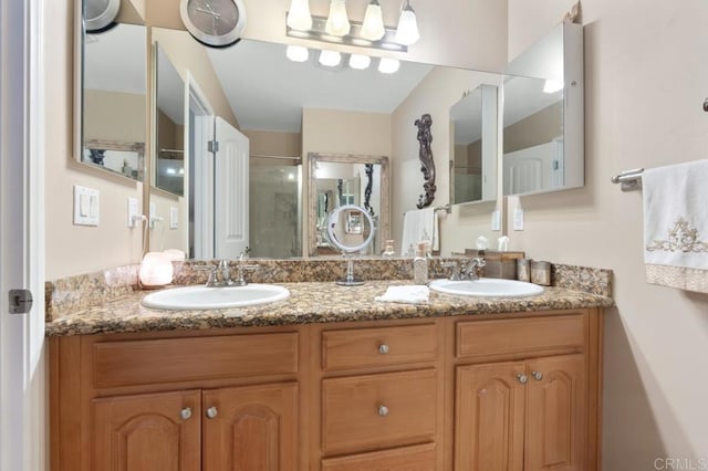 full bath with a sink, a stall shower, and double vanity