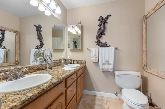 bathroom featuring a sink, baseboards, tile patterned floors, and toilet