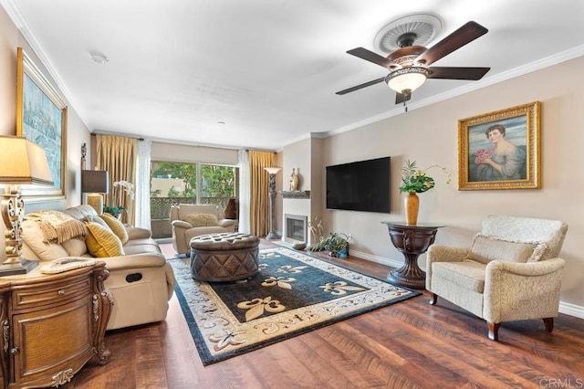 living room featuring crown molding, baseboards, a ceiling fan, and wood finished floors
