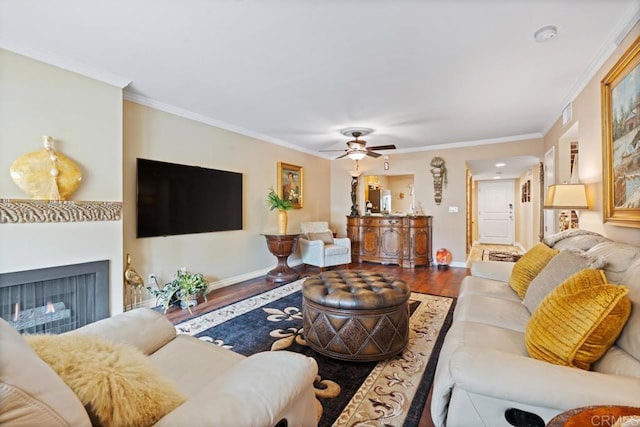 living room with ceiling fan, baseboards, ornamental molding, and wood finished floors