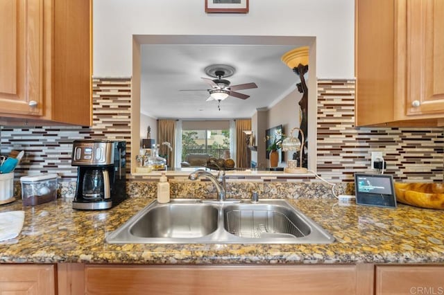 kitchen with crown molding, a ceiling fan, a sink, and tasteful backsplash