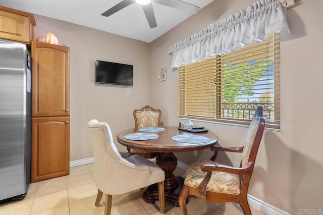 dining space with light tile patterned floors, baseboards, and a ceiling fan