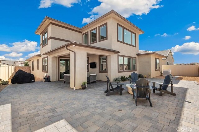 back of property featuring a patio, fence, and stucco siding