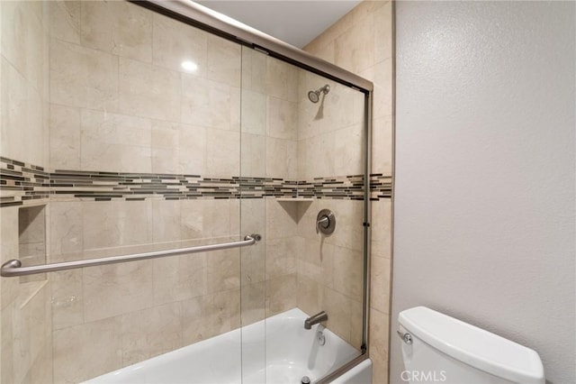 full bathroom with toilet and combined bath / shower with glass door
