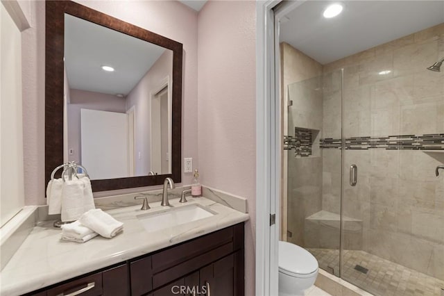 full bathroom featuring toilet, recessed lighting, a shower stall, and vanity