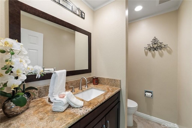 half bath featuring crown molding, vanity, baseboards, and toilet