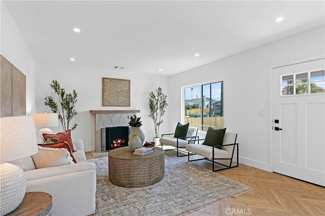 living room featuring a healthy amount of sunlight, a high end fireplace, and recessed lighting