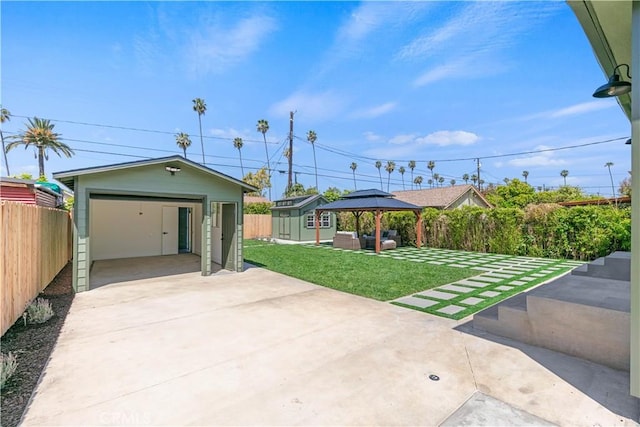 exterior space with driveway, a garage, a gazebo, fence, and an outdoor structure