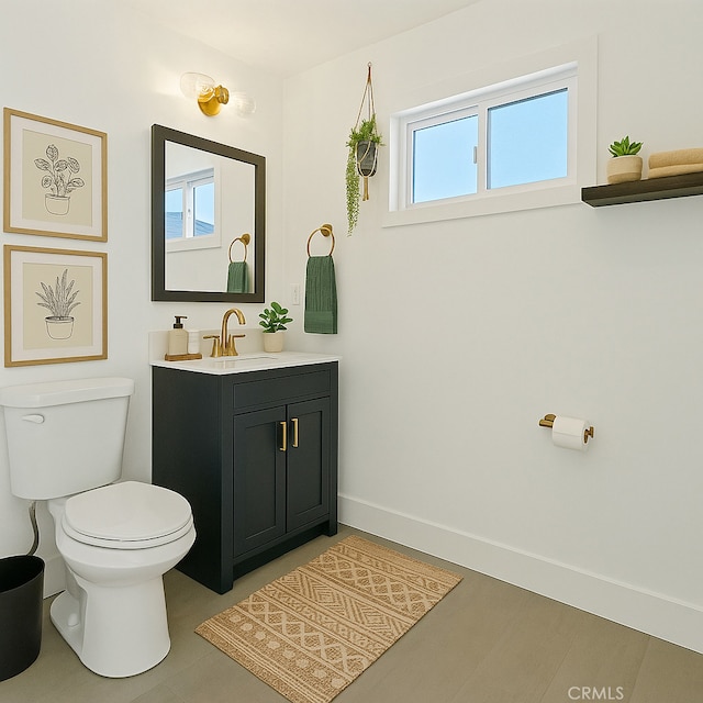 half bath with vanity, baseboards, and toilet