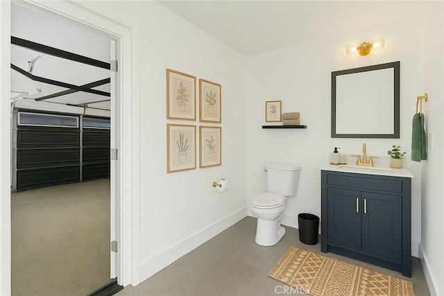 bathroom featuring toilet, baseboards, and vanity