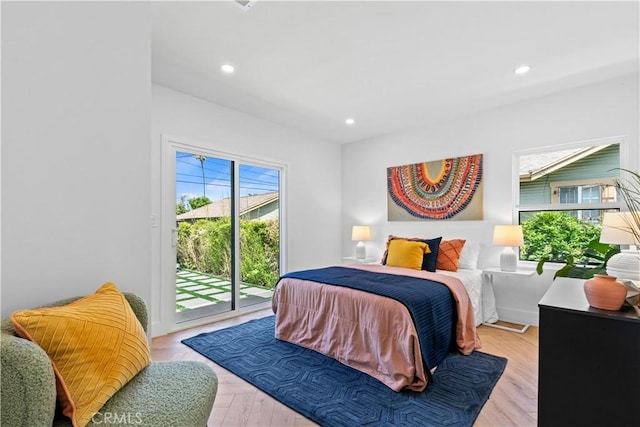 bedroom with recessed lighting, wood finished floors, and access to exterior