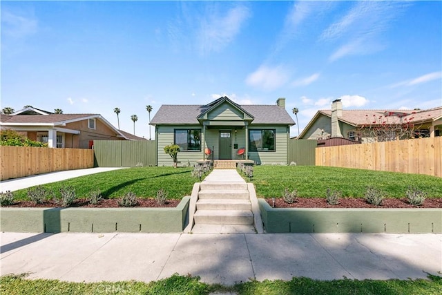 bungalow featuring fence and a front yard