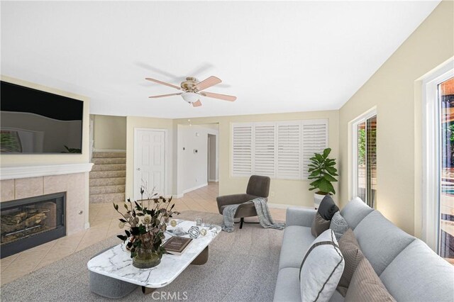 30526 Beryl Pl, Castaic, CA 91384 - living room with ceiling fan, a tiled fireplace, tile patterned flooring, stairway, and baseboards