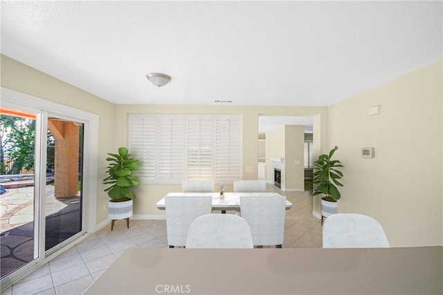 30526 Beryl Pl, Castaic, CA 91384 - dining room featuring baseboards, a fireplace, light tile patterned flooring, and a wealth of natural light