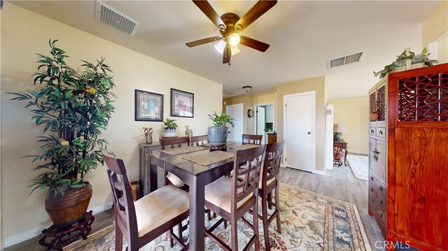 dining area with visible vents, baseboards, ceiling fan, and wood finished floors