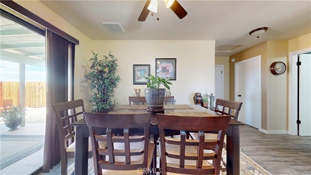 dining room with baseboards, ceiling fan, wood finished floors, and visible vents