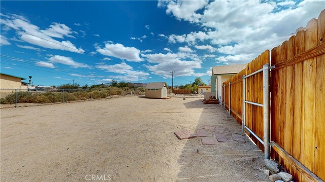 view of yard with a storage unit, fence, and an outbuilding