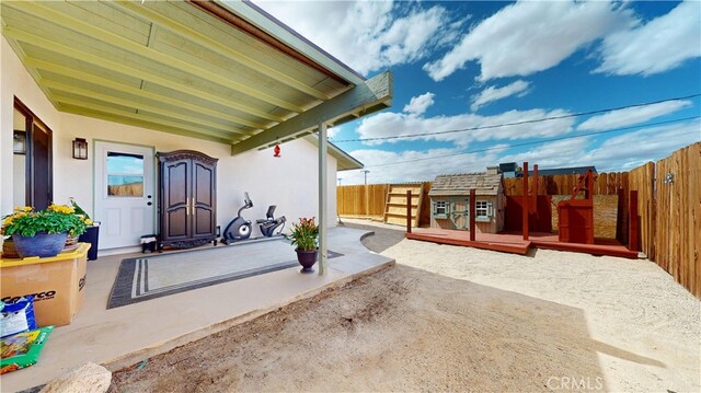 view of patio with a fenced backyard and a deck