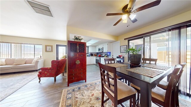 dining room with a ceiling fan, light wood-style flooring, and visible vents