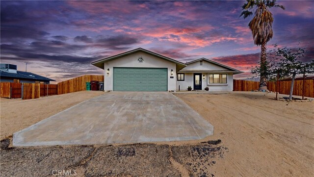ranch-style house with an attached garage, fence, driveway, and covered porch