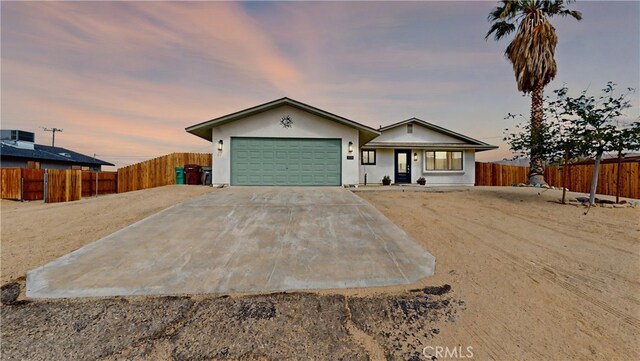 single story home with fence, stucco siding, an attached garage, driveway, and a porch