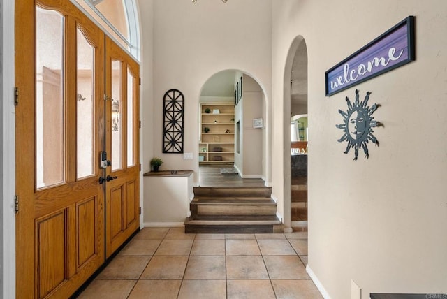 1994 Warmlands Ave, Vista, CA 92084 - foyer entrance with arched walkways, light tile patterned floors, baseboards, french doors, and a high ceiling