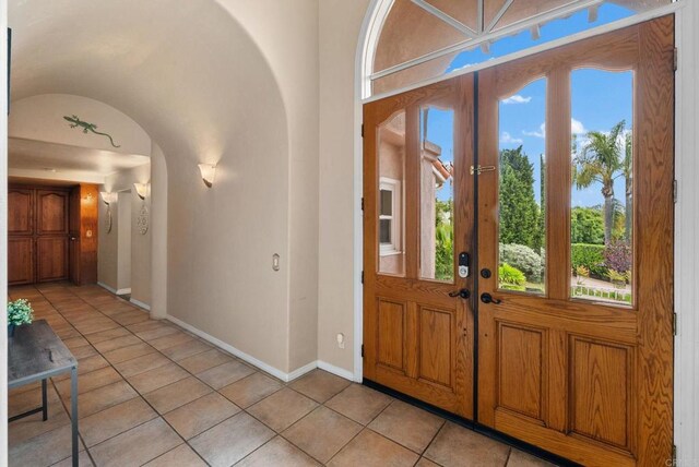 1994 Warmlands Ave, Vista, CA 92084 - entryway featuring french doors, light tile patterned flooring, arched walkways, baseboards, and healthy amount of natural light