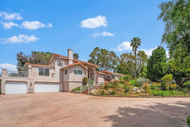 1994 Warmlands Ave, Vista, CA 92084 - mediterranean / spanish-style house featuring driveway, a chimney, stucco siding, an attached garage, and a tile roof