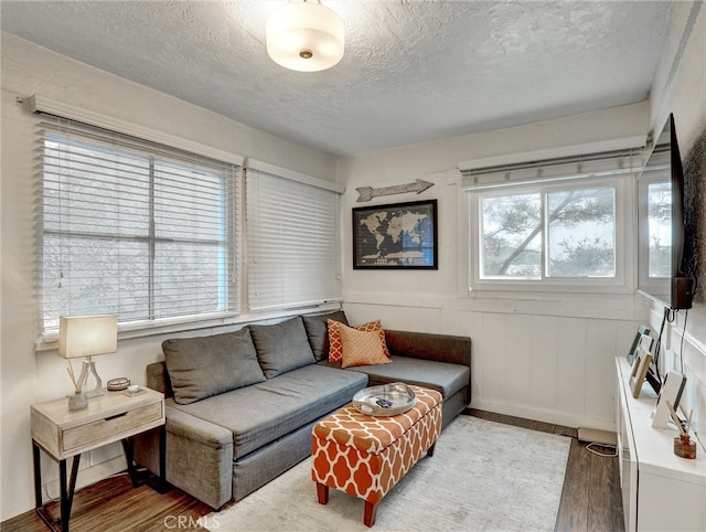 16855 12th St, Sunset Beach, CA 90742 - living room featuring a textured ceiling, wood finished floors, and wainscoting