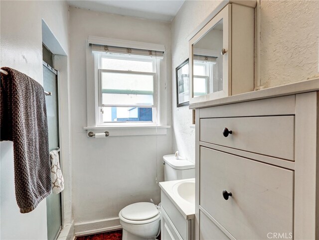 16855 12th St, Sunset Beach, CA 90742 - bathroom featuring toilet, vanity, a shower stall, baseboards, and a textured wall