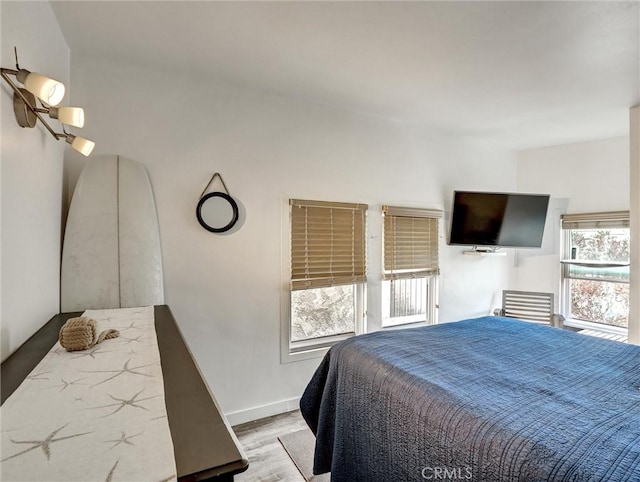 16855 12th St, Sunset Beach, CA 90742 - bedroom with multiple windows, wood finished floors, and baseboards
