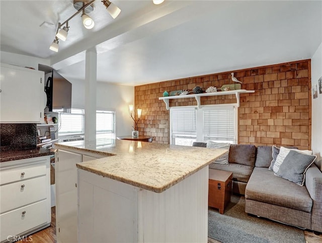 16855 12th St, Sunset Beach, CA 90742 - kitchen featuring open floor plan, white cabinetry, stone counters, decorative backsplash, and light wood-style floors