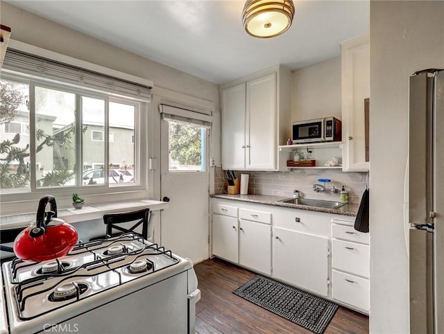 16855 12th St, Sunset Beach, CA 90742 - kitchen with white appliances, a sink, tasteful backsplash, and dark wood finished floors