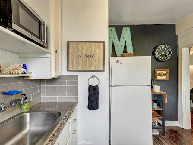 16855 12th St, Sunset Beach, CA 90742 - kitchen featuring freestanding refrigerator, a sink, stainless steel microwave, and white cabinetry