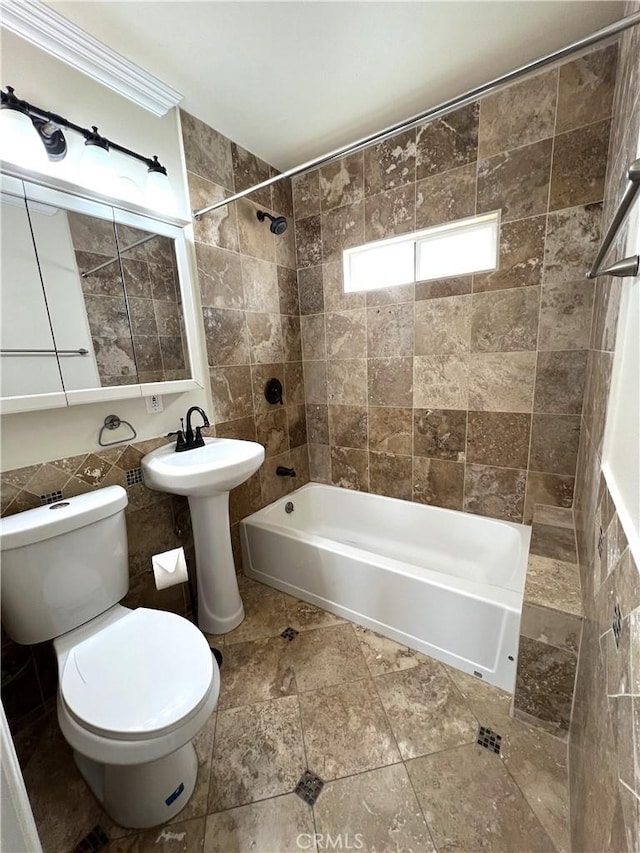 full bath with tile walls, shower / bathing tub combination, and toilet