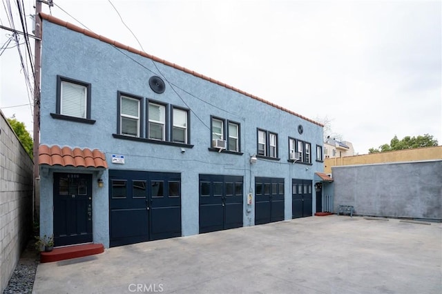 garage with cooling unit and concrete driveway
