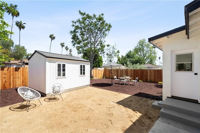 3420 Lifur Ave, Los Angeles, CA 90032 - fenced backyard featuring outdoor dining area, an outdoor structure, a patio, and entry steps