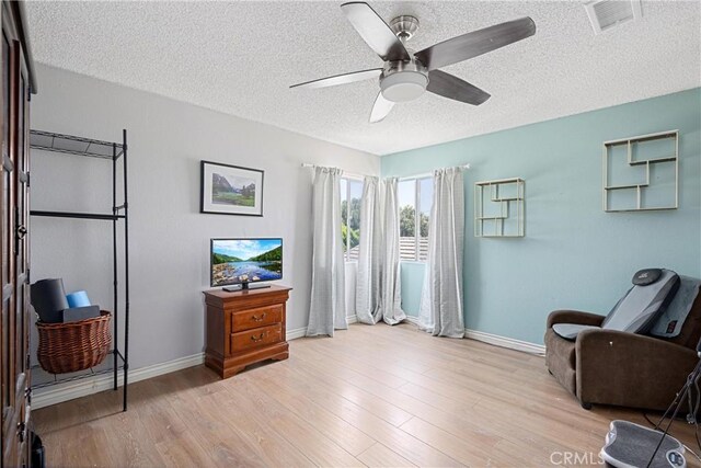 875 S Rexford St, Rialto, CA 92376 - living area with a textured ceiling, a ceiling fan, baseboards, and light wood-type flooring