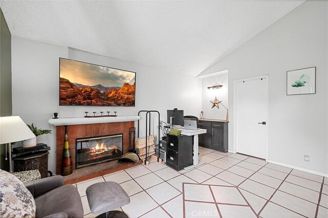 875 S Rexford St, Rialto, CA 92376 - living room featuring vaulted ceiling, a glass covered fireplace, light tile patterned floors, and baseboards