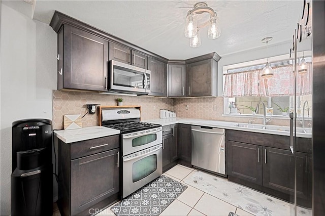 875 S Rexford St, Rialto, CA 92376 - kitchen featuring appliances with stainless steel finishes, a sink, dark brown cabinetry, and tasteful backsplash