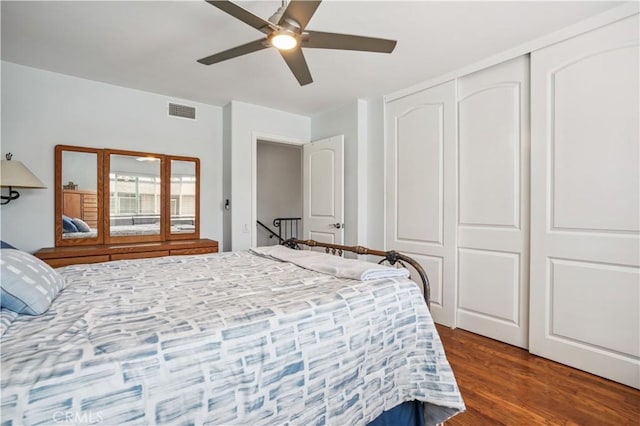 bedroom featuring ceiling fan, a closet, dark wood finished floors, and visible vents