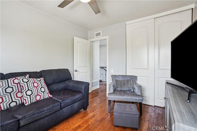 living room featuring visible vents, ceiling fan, and wood finished floors
