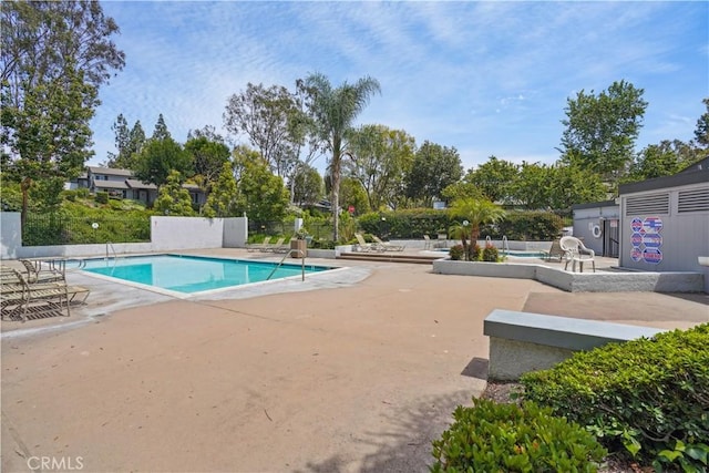 community pool featuring a patio and fence