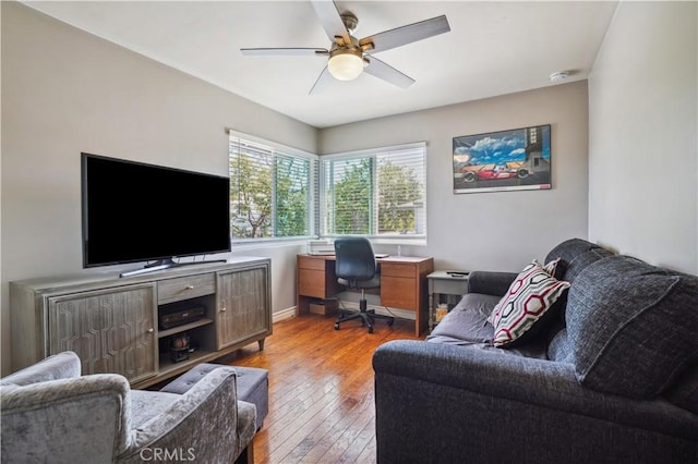 home office featuring baseboards, light wood-style flooring, and ceiling fan