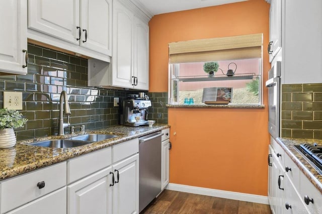 kitchen with backsplash, appliances with stainless steel finishes, a sink, white cabinets, and dark wood-style floors