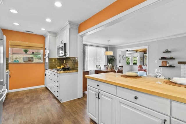 kitchen with backsplash, white cabinets, dark wood-style floors, butcher block counters, and stainless steel appliances