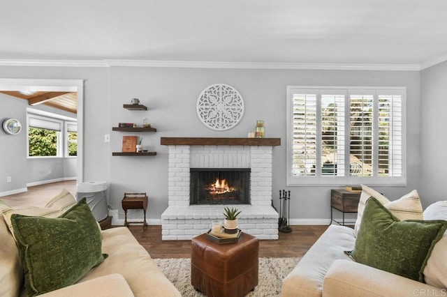 living room featuring baseboards, crown molding, a brick fireplace, and wood finished floors