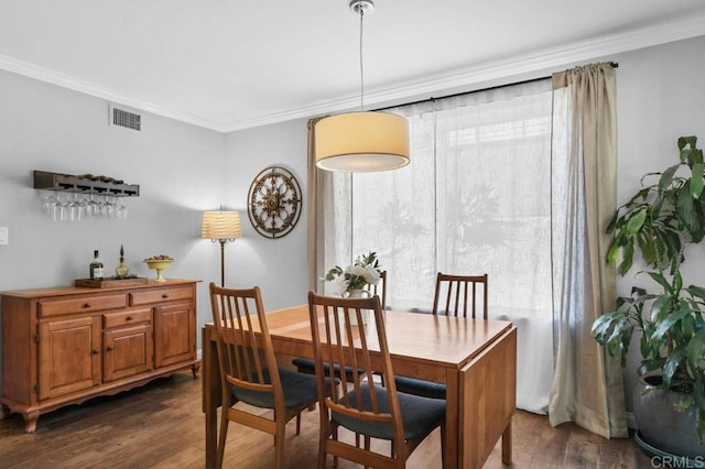 dining area with a wealth of natural light, ornamental molding, dark wood finished floors, and visible vents