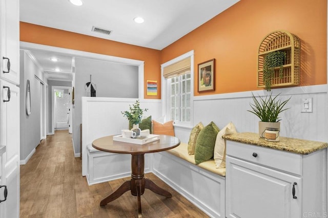 interior space featuring visible vents, recessed lighting, wainscoting, and wood finished floors