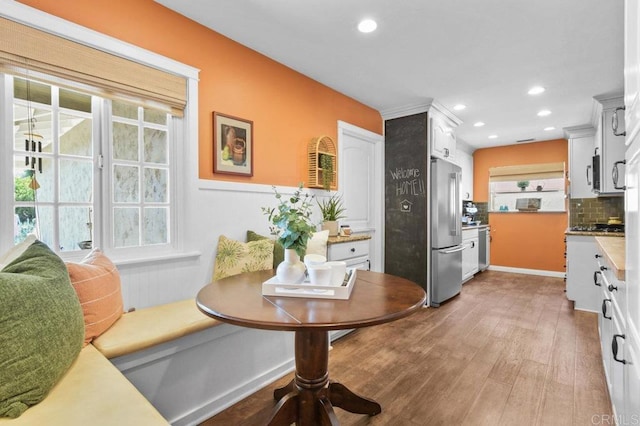 interior space with decorative backsplash, appliances with stainless steel finishes, light wood-style floors, recessed lighting, and white cabinetry